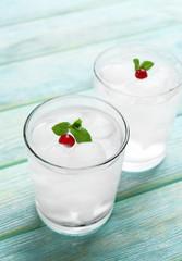 Glasses with ice cubes on wooden table