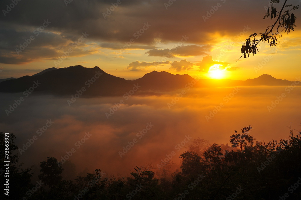 Wall mural mountain landscape above the clouds at sunrise