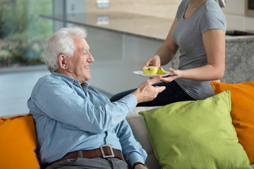 Daughter giving ill grandpa apple