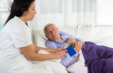 Fototapeta premium Doctor shows the patient how to use daily dose pills