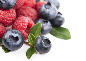 Many blueberries, raspberries. Isolated white