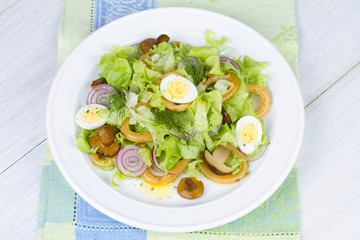 Fresh salad with mushrooms, squid and quail eggs
