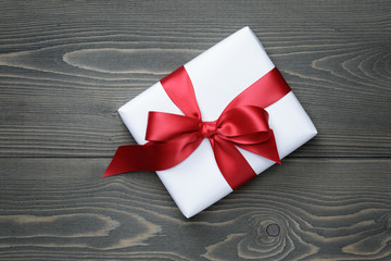 gift box with red bow on wood table