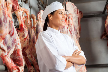 Happy Female Butcher Standing In Slaughterhouse