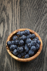 ripe isabella grapes in wood bowl on table