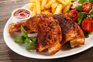 Grilled chicken legs with chips and vegetables