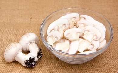 Sliced mushrooms in bowl on placemat jute