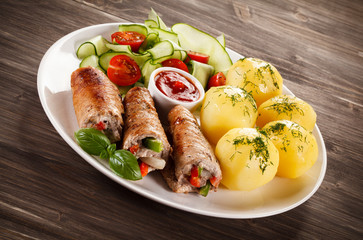 Wrapped pork chop, boiled potatoes and vegetables
