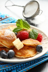 Dutch mini pancakes called poffertjes with berries