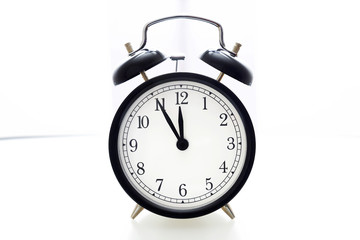 Oldfashioned black glossy alarm clock showing 5 to 12