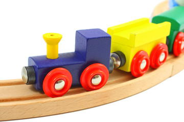 Naklejka premium Wooden train toy on rails isolated on white