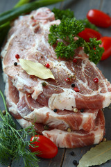 Fresh raw pork shoulder chop with spices and vegetables