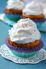 Cupcakes with white cream icing on blue wooden background