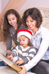 Mom reading a Christmas story with children.