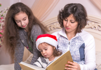 Mom reading a Christmas story with children.