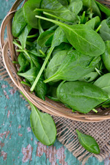 spinach in a basket on wooden surface