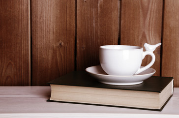 Old books and cup of coffee on table