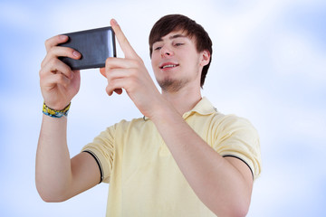 Young man with smiling eyes looking at his smartphone