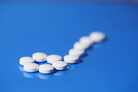 pills. White medical pills on blue background