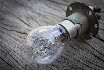 A tungsten bulb on a wooden floor