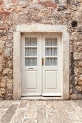 Fototapeta na wymiar white classic door in ancient stone building