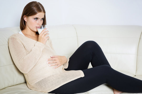 Worried pregnant woman drinking milk