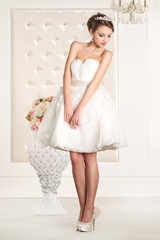 Fototapeta na wymiar Gorgeous bride with white dress with flowers bouquet