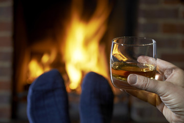 Man With Glass Of Whisky Relaxing By Fire