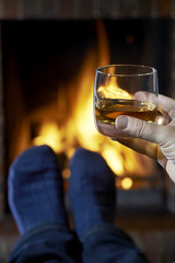 Man With Glass Of Whisky Relaxing By Fire