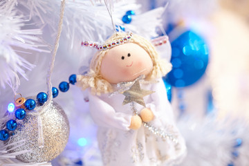 Christmas toys in the form of an angel hanging on the tree next
