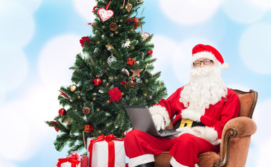 man in costume of santa claus with laptop