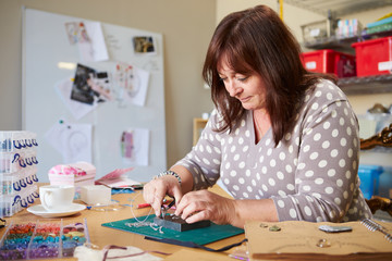 Fototapeta premium Mature Woman Making Jewelry At Home