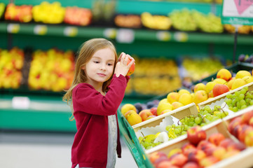 Little girl choosing an apple in a store