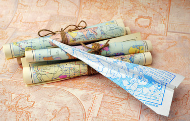 old rolled maps and paper airplane