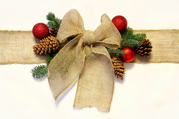 Burlap Christmas Bow, and Ornaments with Pinecones Isolated on W