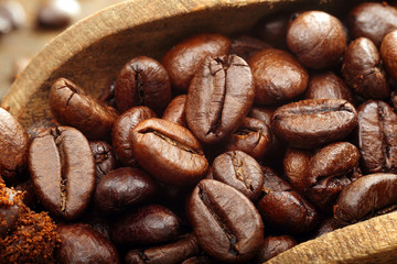 Studio macro coffee beans in wooden spoon on brown background