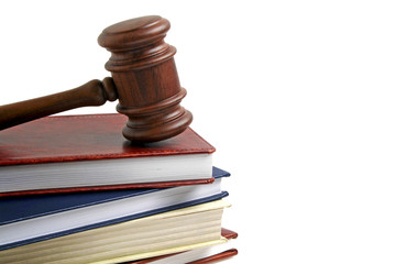 Wooden gavel and books isolated on white background