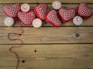 red check hearts with candles on rustic wooden background