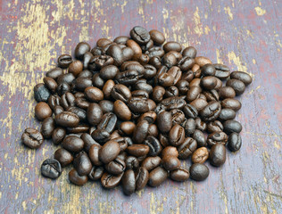 Roasted coffee beans on textured wood.
