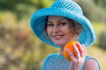 Woman in blue  holding  one orange