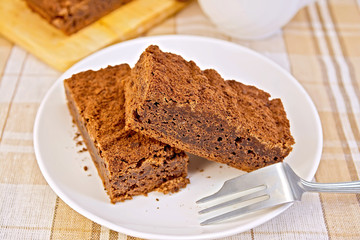 Pie chocolate in plate with fork on tablecloth