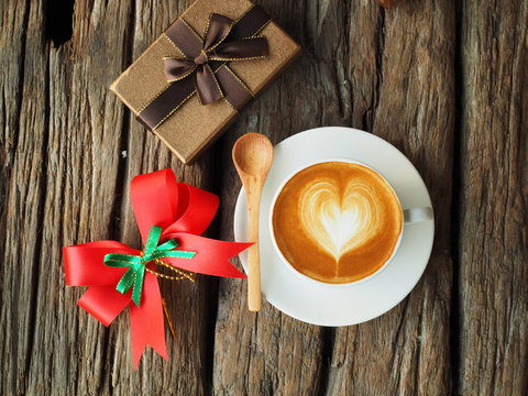 Coffee latte art and the X-mas present box on the wood backgroun