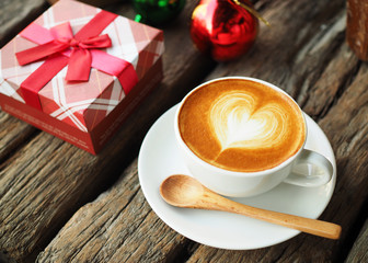 Coffee latte art and the X-mas present box on the wood backgroun