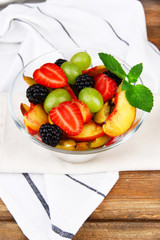 fresh tasty fruit salad on wooden table