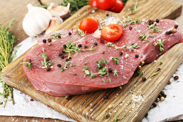 Raw beef steak on wooden table