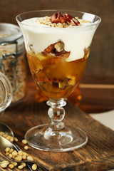 Tasty dessert with oat flakes and honey, on table
