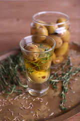 Green olives in oil with spices and rosemary in glass jars