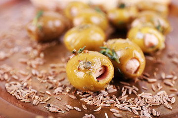 Green olives in oil with spices and bread on tray on table