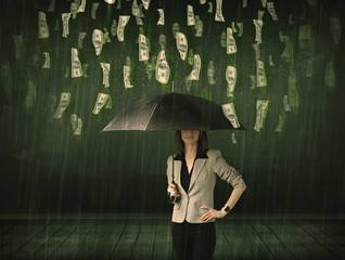 Businesswoman standing with umbrella in dollar bill rain concept