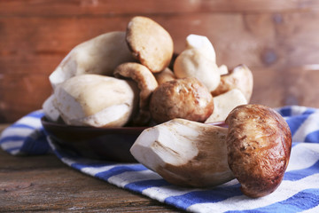 Wild mushrooms on plate on wooden background